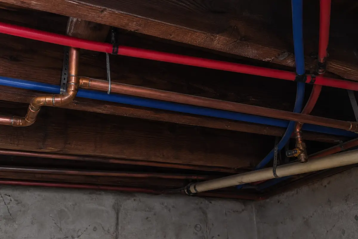 Residential copper and PEX supply lines running along basement joists